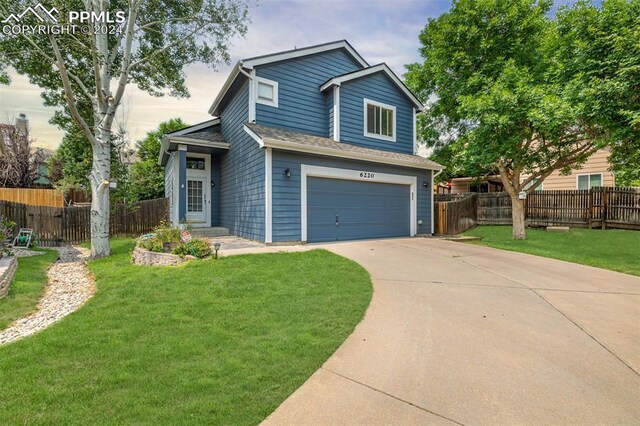 view of front of property featuring a front yard and a garage