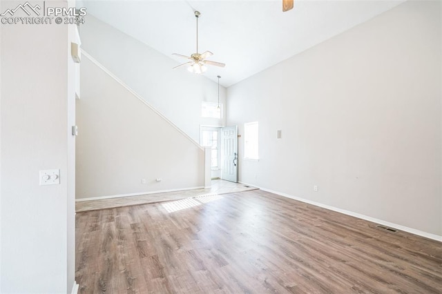 unfurnished living room featuring hardwood / wood-style floors, high vaulted ceiling, and ceiling fan