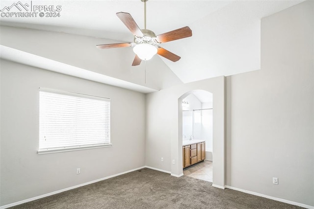 carpeted empty room with ceiling fan and lofted ceiling