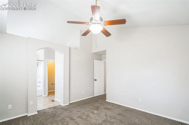 carpeted empty room with ceiling fan and high vaulted ceiling