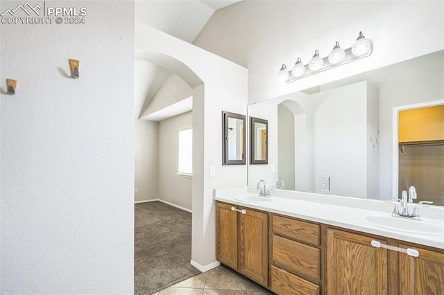 bathroom featuring vanity, tile patterned flooring, and vaulted ceiling