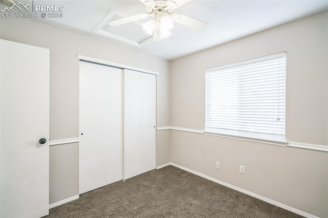 unfurnished bedroom with a closet, ceiling fan, and dark carpet