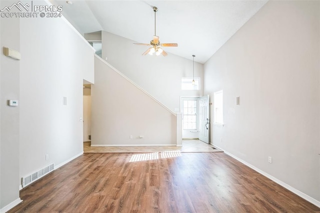 unfurnished living room with high vaulted ceiling, hardwood / wood-style floors, and ceiling fan