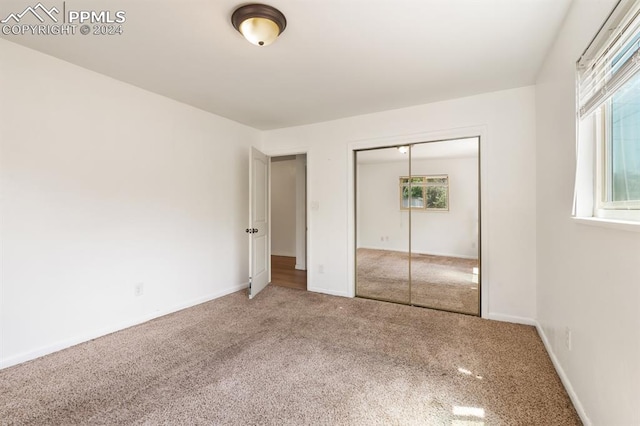 unfurnished bedroom with a closet and carpet flooring