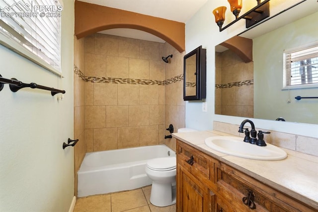 full bathroom featuring tile patterned flooring, toilet, vanity, and tiled shower / bath