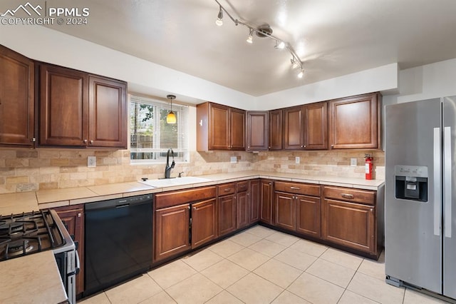 kitchen with track lighting, stainless steel appliances, sink, decorative backsplash, and light tile patterned flooring