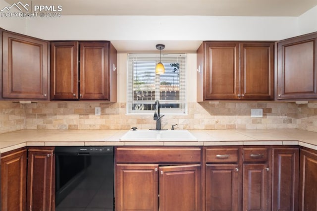 kitchen with sink, black dishwasher, pendant lighting, and backsplash