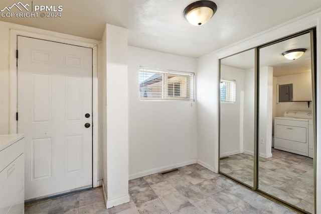 entrance foyer with washer / dryer, electric panel, and light tile patterned floors