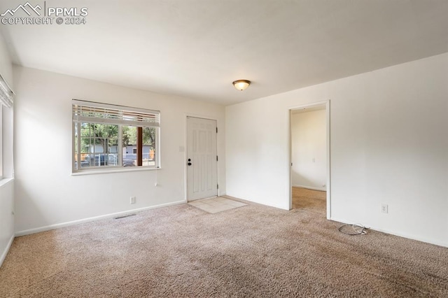 unfurnished room with light colored carpet