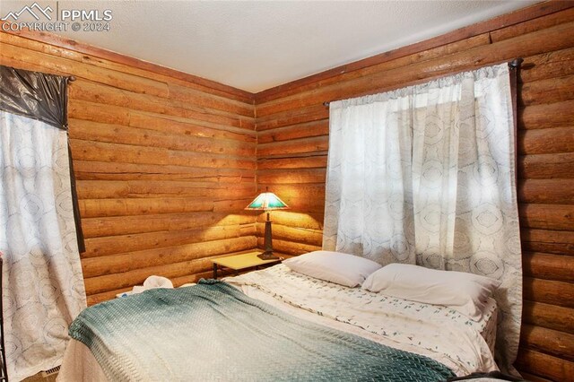 bedroom featuring log walls