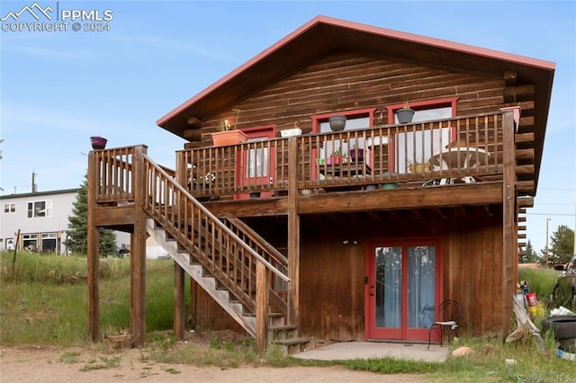 rear view of property featuring a wooden deck