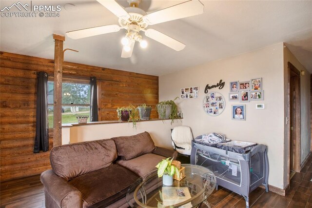 living room with ceiling fan and dark hardwood / wood-style flooring