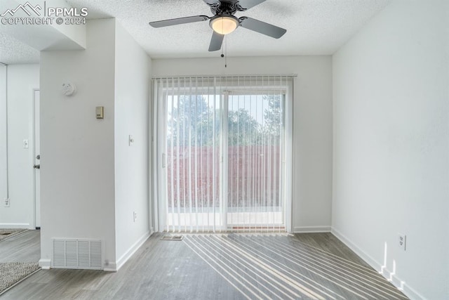 interior space with visible vents, a textured ceiling, and wood finished floors