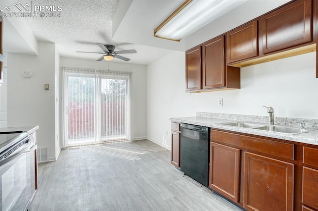 kitchen featuring black dishwasher, light wood finished floors, light countertops, visible vents, and a sink