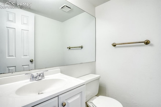 half bath featuring toilet, visible vents, and vanity