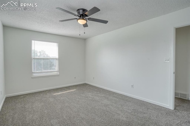 carpeted spare room featuring visible vents, ceiling fan, a textured ceiling, and baseboards