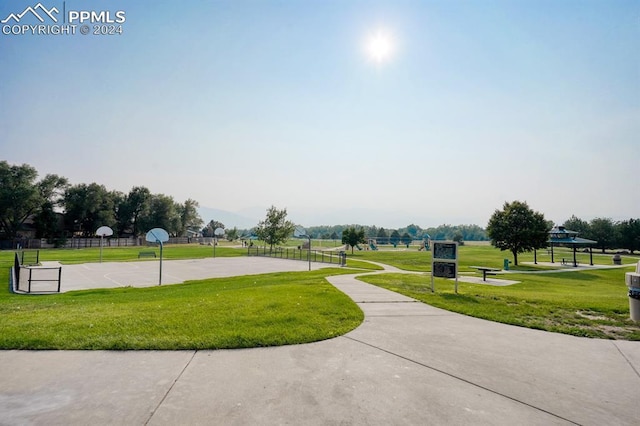 view of community with community basketball court, a yard, and fence