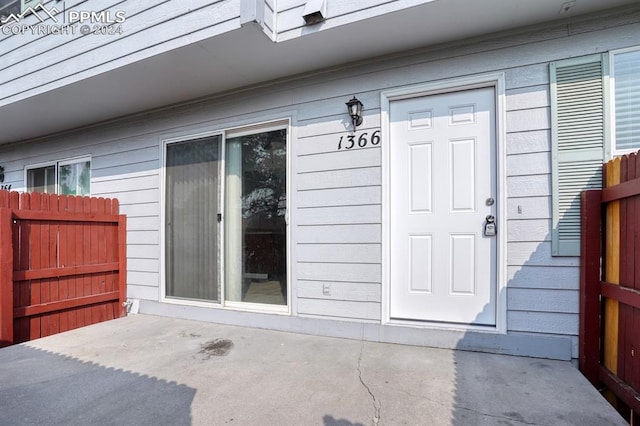 view of exterior entry featuring fence