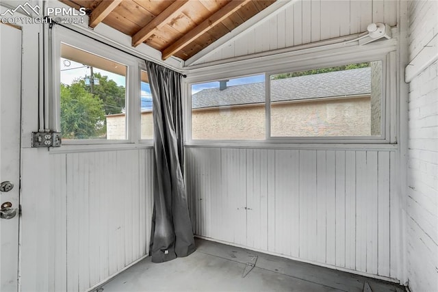 unfurnished sunroom with wood ceiling and vaulted ceiling with beams