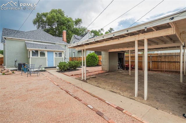 back of house with an outdoor structure and central AC unit