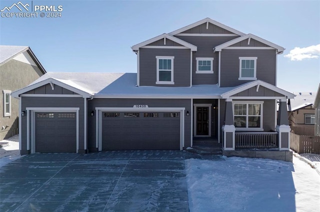 craftsman-style home featuring a garage, covered porch, board and batten siding, and driveway