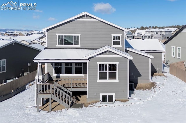 snow covered property featuring fence and a residential view