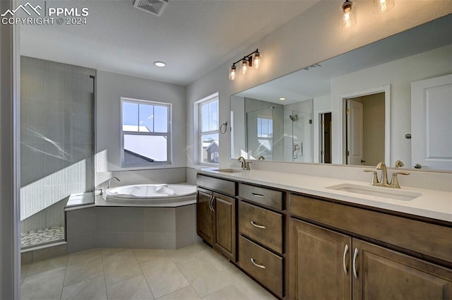 bathroom featuring plus walk in shower, vanity, and tile patterned flooring