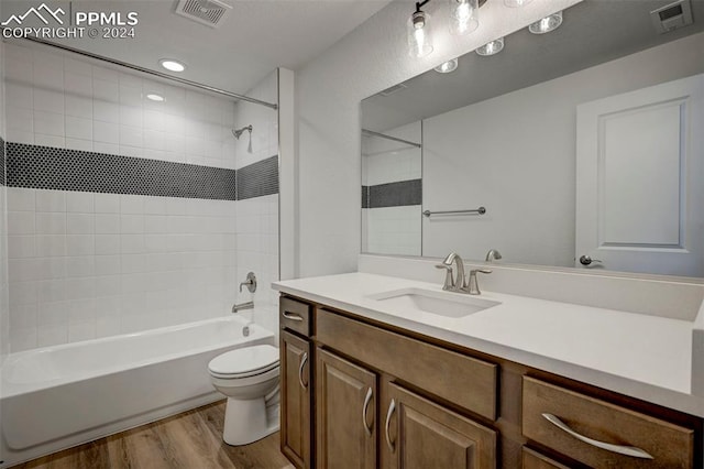 full bath featuring visible vents, toilet, shower / bathtub combination, and wood finished floors