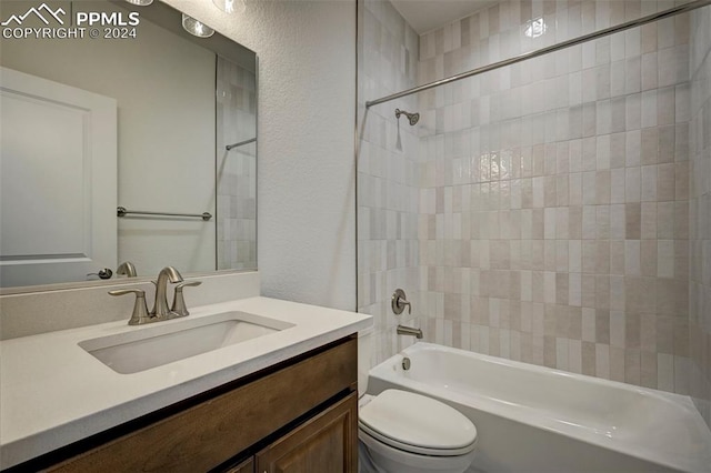 full bathroom featuring tiled shower / bath combo, toilet, and vanity