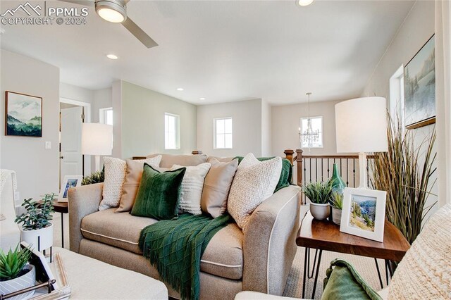 living room with ceiling fan with notable chandelier