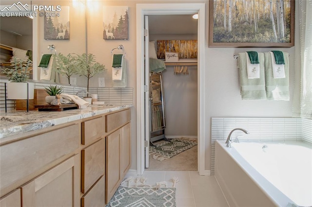 bathroom with vanity, tile patterned flooring, and a tub