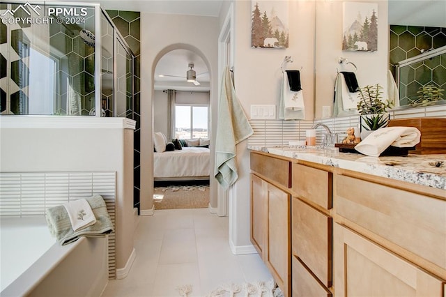 bathroom with a bathtub, backsplash, tile patterned floors, vanity, and ceiling fan