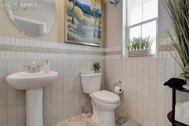 bathroom featuring tile patterned flooring, tile walls, tasteful backsplash, and toilet