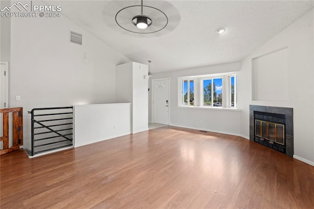 unfurnished living room featuring lofted ceiling and hardwood / wood-style flooring