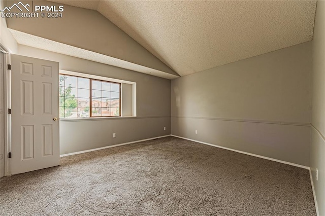 carpeted empty room with a textured ceiling and lofted ceiling