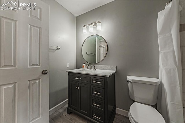 bathroom with vanity, toilet, and hardwood / wood-style floors