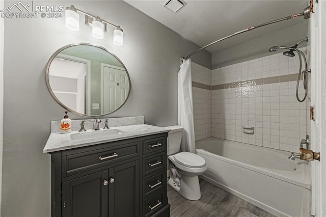 full bathroom featuring hardwood / wood-style floors, vanity, toilet, and shower / bath combo