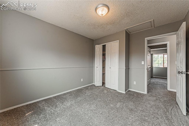 unfurnished bedroom featuring a textured ceiling, a closet, and carpet flooring