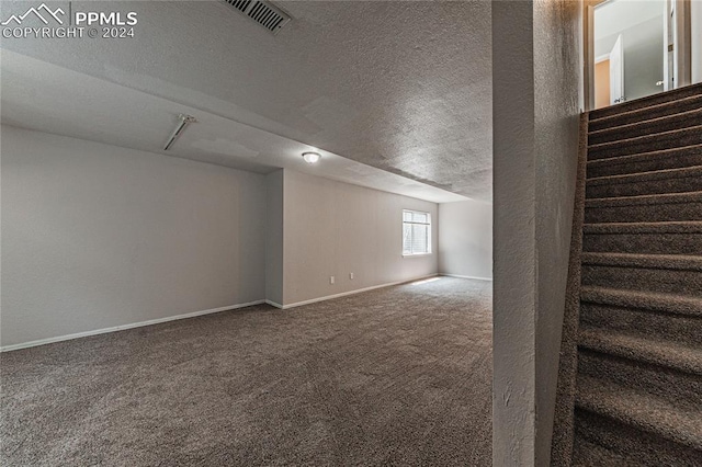 basement featuring carpet and a textured ceiling