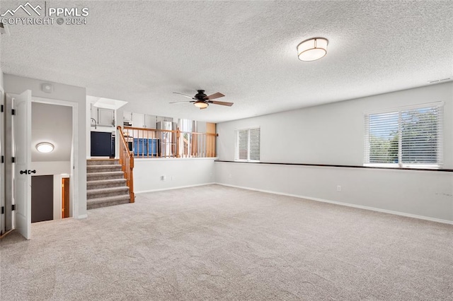 unfurnished living room with carpet floors, a textured ceiling, and ceiling fan