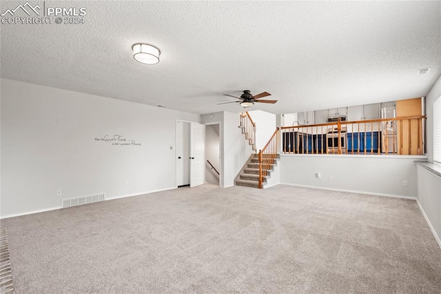 carpeted empty room featuring ceiling fan and a textured ceiling