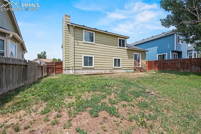 rear view of property with a lawn