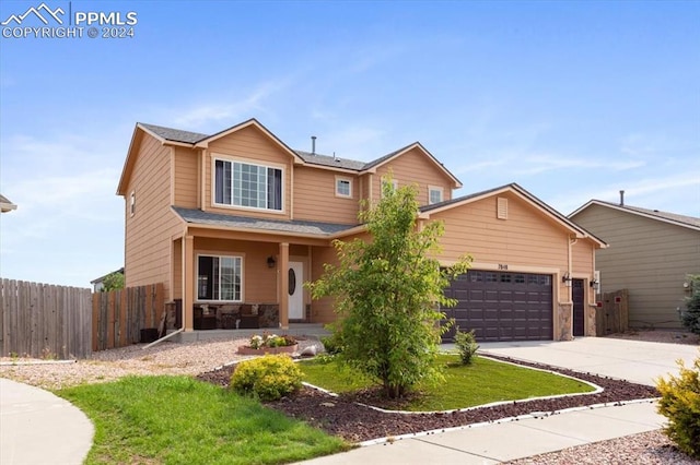 7848 Chasewood Loop, Colorado Springs, CO 80908 - view of front facade with a porch, fence, a garage, driveway, and stone siding