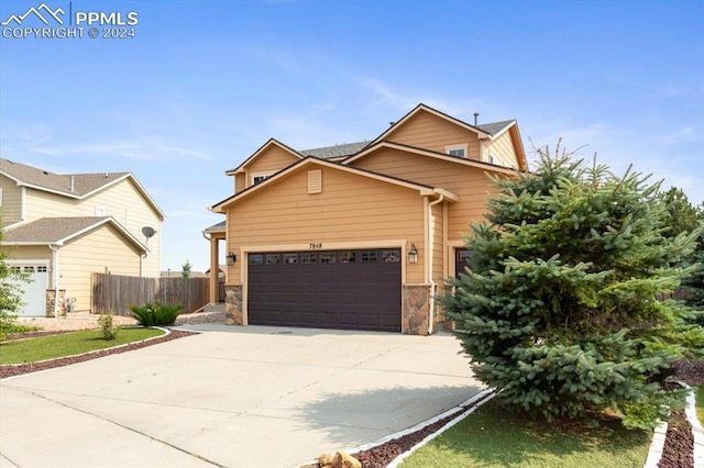 7848 Chasewood Loop, Colorado Springs, CO 80908 - view of front facade with concrete driveway, stone siding, an attached garage, and fence