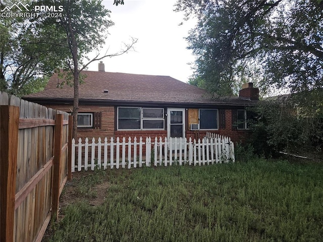 rear view of house featuring a yard