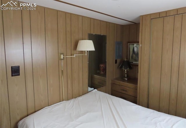 bedroom with wooden walls and a closet