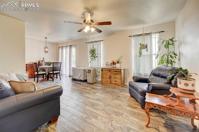 living room featuring hardwood / wood-style floors, a textured ceiling, and ceiling fan