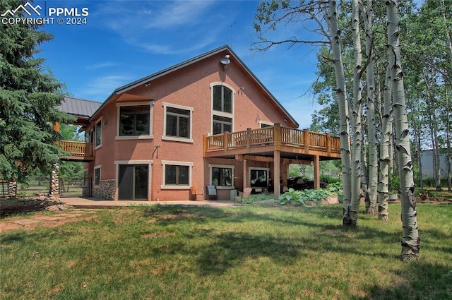 rear view of house featuring a deck, a yard, and a patio