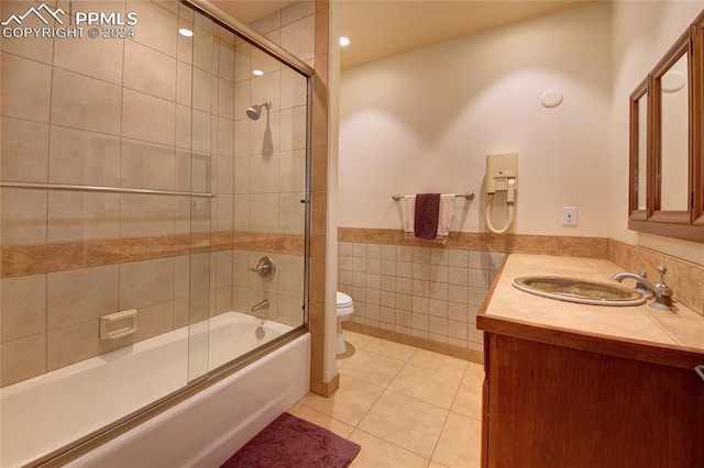 full bathroom featuring tile patterned floors, vanity, toilet, and enclosed tub / shower combo