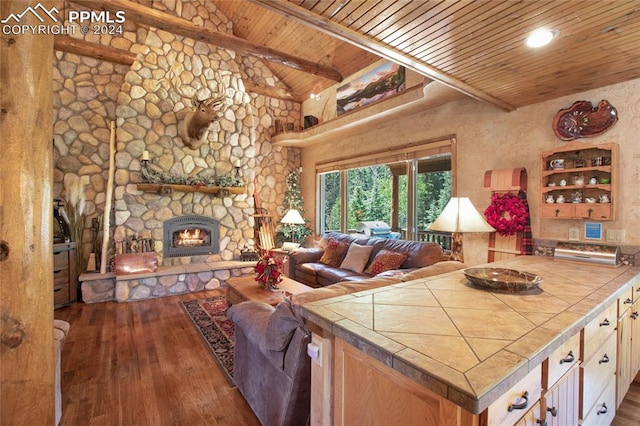 living room featuring a stone fireplace, beamed ceiling, wooden ceiling, and dark hardwood / wood-style flooring